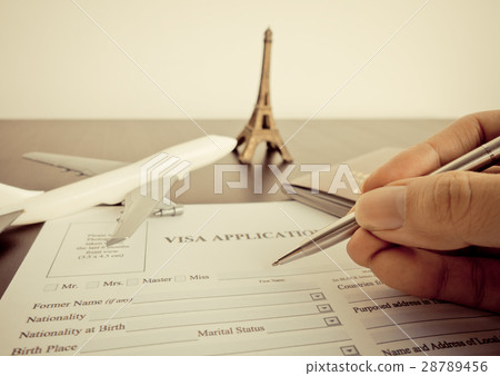Business traveler is filling the Visa form to travel to paris 28789456