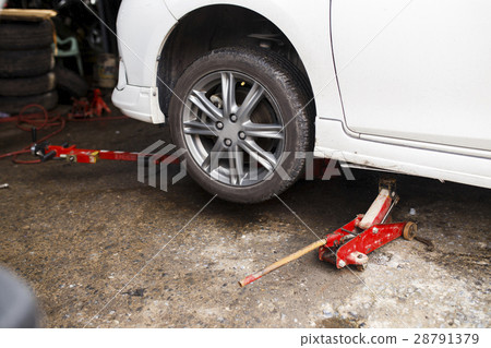 Jacking up a car for change the wheel. Jacking up a car for change the wheel. 28791379