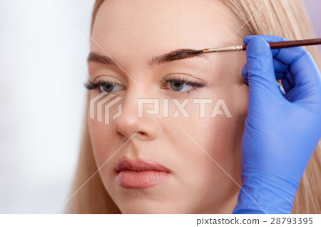 Cosmetologist making permanent eyebrows usin Cosmetologist making permanent eyebrows usin 28793395