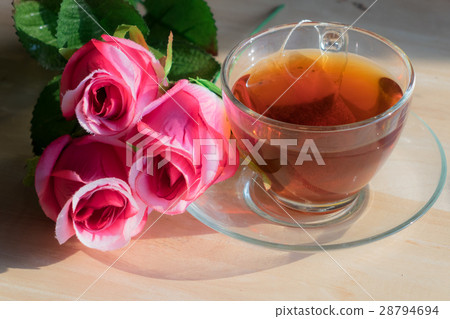 Rose with hot tea on a wooden table. Rose with hot tea on a wooden table. 28794694