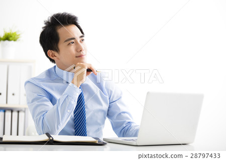 young businessman working on laptop and thinking 28797433