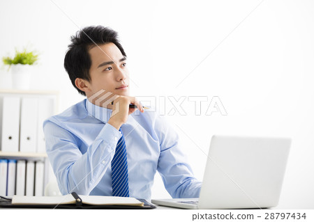 young businessman working on laptop and thinking young businessman working on laptop and thinking 28797434
