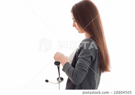 young girl stands sideways and holds headphones young girl stands sideways and holds headphones 28804505