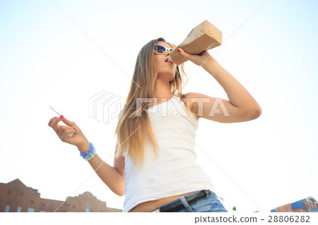 girl drinks from a bottle in a paper bag. 28806282