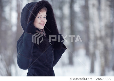 Winter woman in a fur coat on the snow outside 28809099