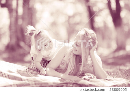 autumn park Mother and daughter lying on the ground playing autumn park Mother and daughter lying on the ground playing 28809905