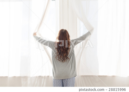 Female opens the curtains in the morning 28815996