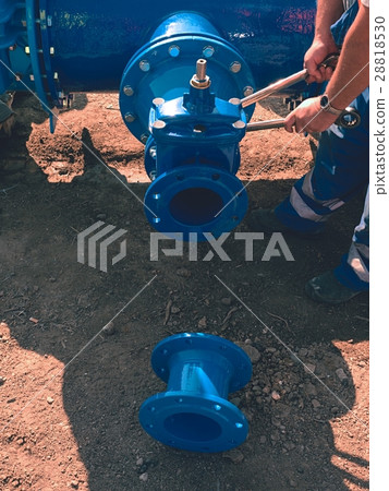 Worker screwing Gate valve with nuts on piping. Worker screwing Gate valve with nuts on piping. 28818530