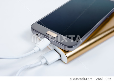 Golden powerbank with smart phone on background 28819086