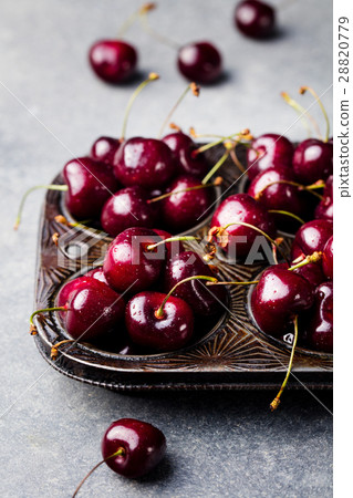 Black cherries in vintage dish. Stone background. 28820779