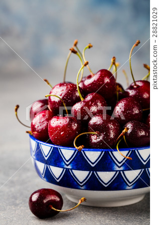 Black cherries in a bowl. Grey stone background. 28821029