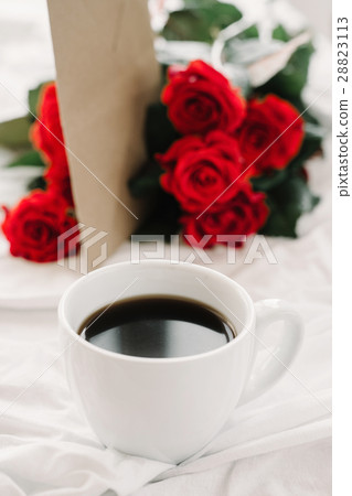 cup of coffee and a bouquet of red roses, envelope cup of coffee and a bouquet of red roses, envelope 28823113