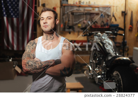 Portrait of muscular male standing in the garage 28824377