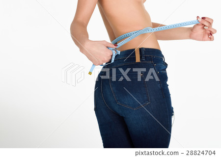 Young woman measuring waist with a tape Young woman measuring waist with a tape 28824704