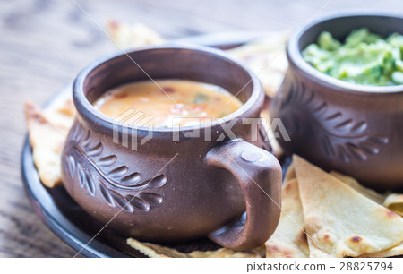 Bowls of guacamole and queso with tortilla chips Bowls of guacamole and queso with tortilla chips 28825794