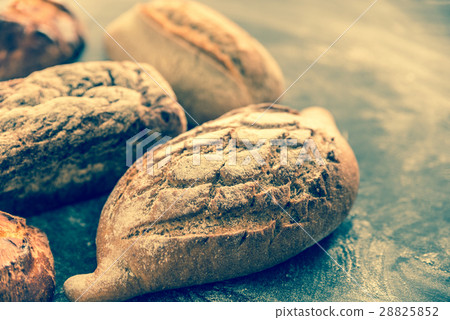 Whole grain breads on the dark wooden background Whole grain breads on the dark wooden background 28825852