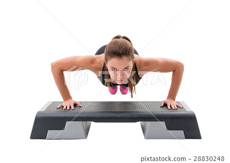 Young fitness trainer exercising on step platform 28830248