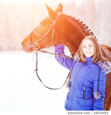Young teenage girl with her horse in winter park 28830483
