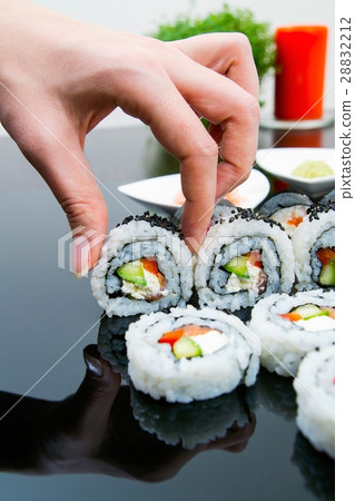 Hand holding sushi on black background Hand holding sushi on black background 28832212
