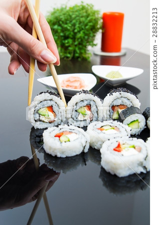 Hand holding stick with maki sushi set Hand holding stick with maki sushi set 28832213