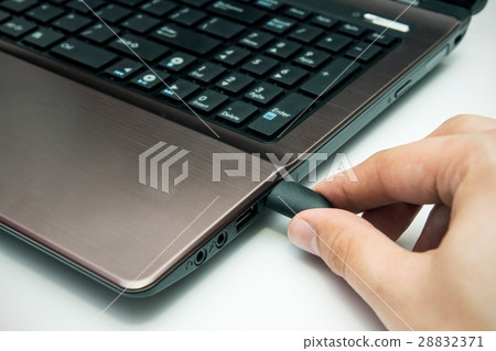 Hand connecting USB cable to laptop Hand connecting USB cable to laptop 28832371