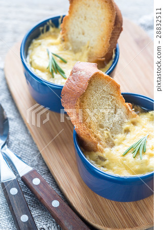 Bowls of onion soup on the wooden board Bowls of onion soup on the wooden board 28832511
