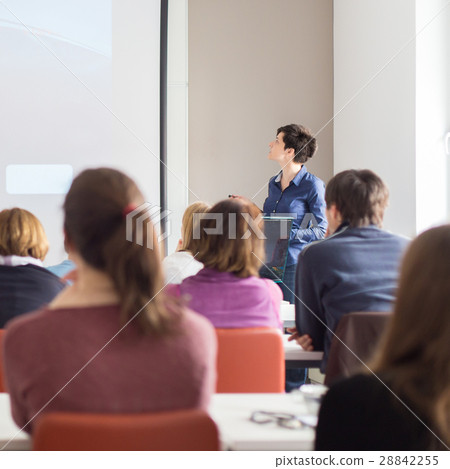 Woman giving presentation in lecture hall at 28842255
