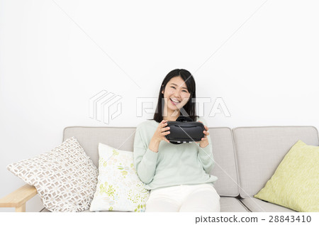 A young lady who enjoys VR at home 28843410
