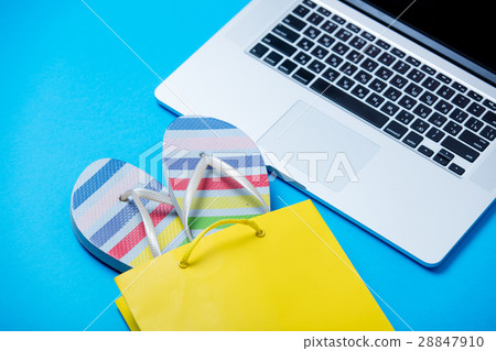 colorful sandals in shopping bag and cool laptop 28847910