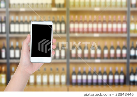 Girl hand hold white mobile with blurry wine shop, Girl hand hold white mobile with blurry wine shop, 28848446
