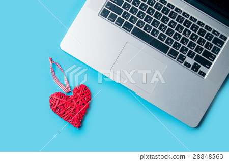 beautiful heart shaped toy lying near laptop on the wonderful bl beautiful heart shaped toy lying near laptop on the wonderful bl 28848563