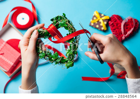 white caucasian female hands wrapping heart shaped toy on the wo white caucasian female hands wrapping heart shaped toy on the wo 28848564
