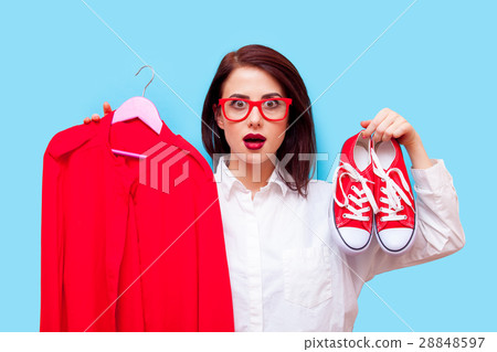 beautiful young woman with shirt on hanger and gumshoes standing 28848597