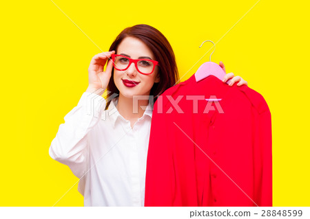 beautiful young woman with shirt on hanger standing in front of 28848599
