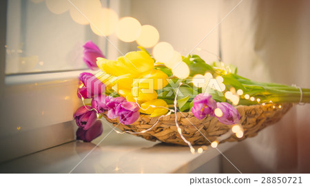 bunch of tulips and garland on windowsill 28850721