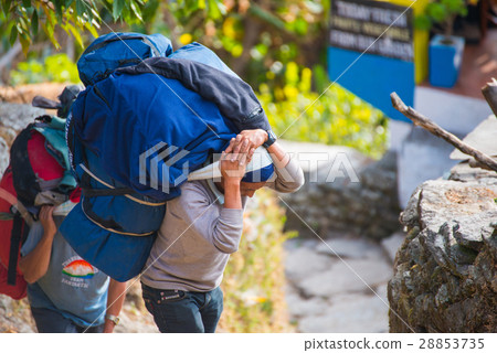 Sherpas carry heavy backpack and walk to mountain  28853735