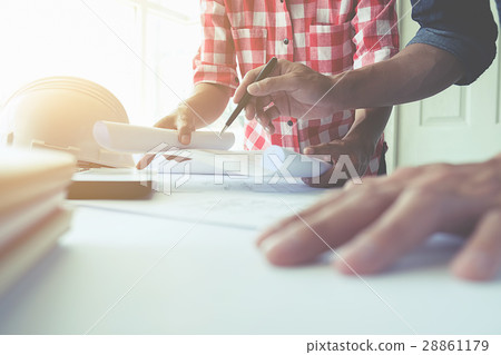 Hands of Engineer working on blueprint 28861179