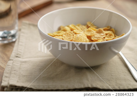 dry corn flakes for breakfast in bowl on table 28864323
