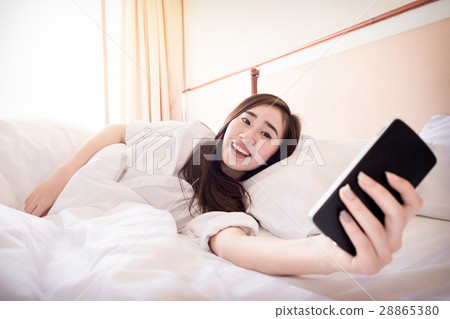 Relaxed woman at home reading a text message on smartphone in he 28865380
