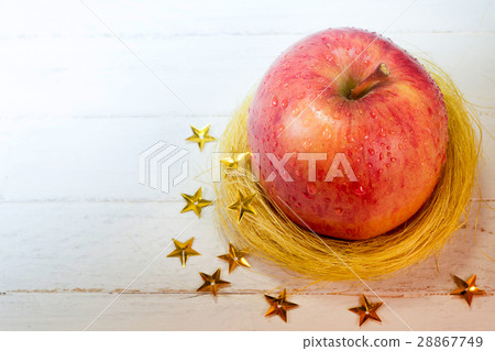 Fresh apple in golden nest and stars on wood Fresh apple in golden nest and stars on wood 28867749