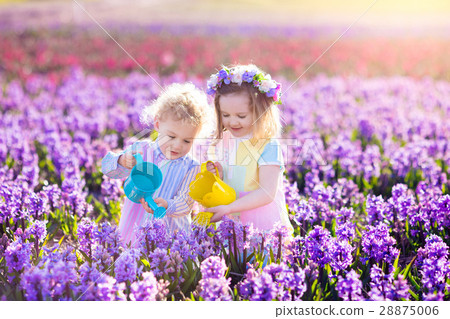 Kids plant and water flowers in spring garden Kids plant and water flowers in spring garden 28875006