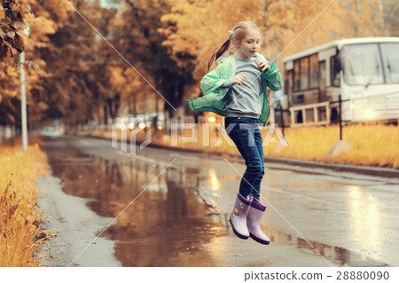 girl jumping in the puddles in the autumn rain girl jumping in the puddles in the autumn rain 28880090