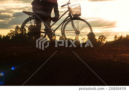 Farmer and bicycle at the sunset. 28888439