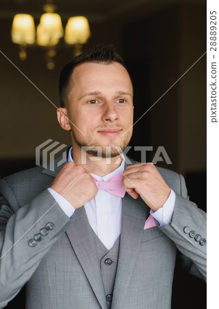 Young man dressing up for wedding celebration. Young man dressing up for wedding celebration. 28889205