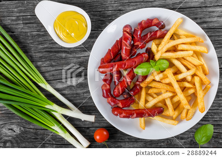 french fries and sausages on plate, top view 28889244