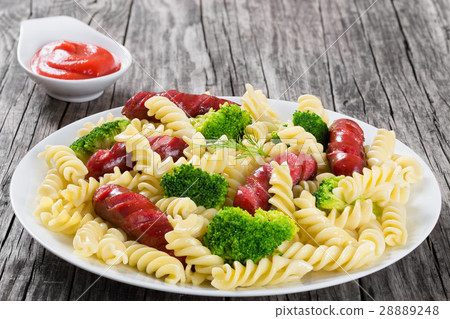 Pasta salad with broccoli and grilled sausages 28889248