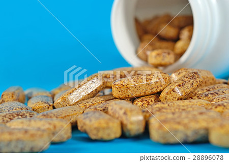 图库照片 pills spill out from bottle on a blue