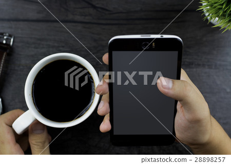 Using smartphone and holding a coffee cup Using smartphone and holding a coffee cup 28898257