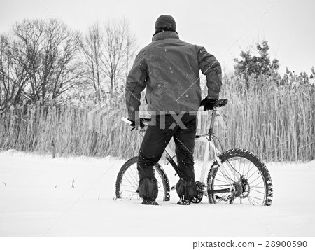 Sportsman with mountain bike lost in snow. 28900590