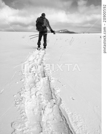Hiker with backpack snowshoeing  in deep drift. 28900592